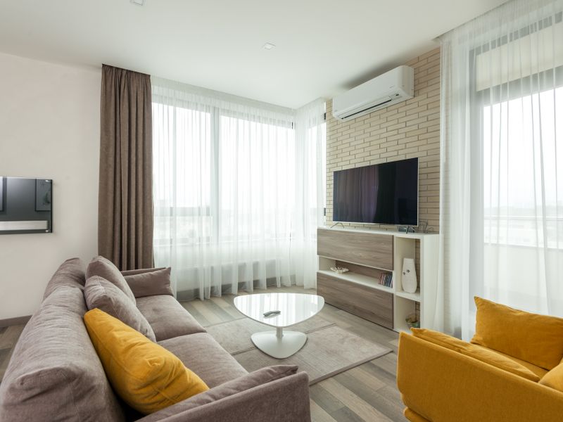 Modern wall-mounted air conditioning unit installed in a bright, comfortable living room
